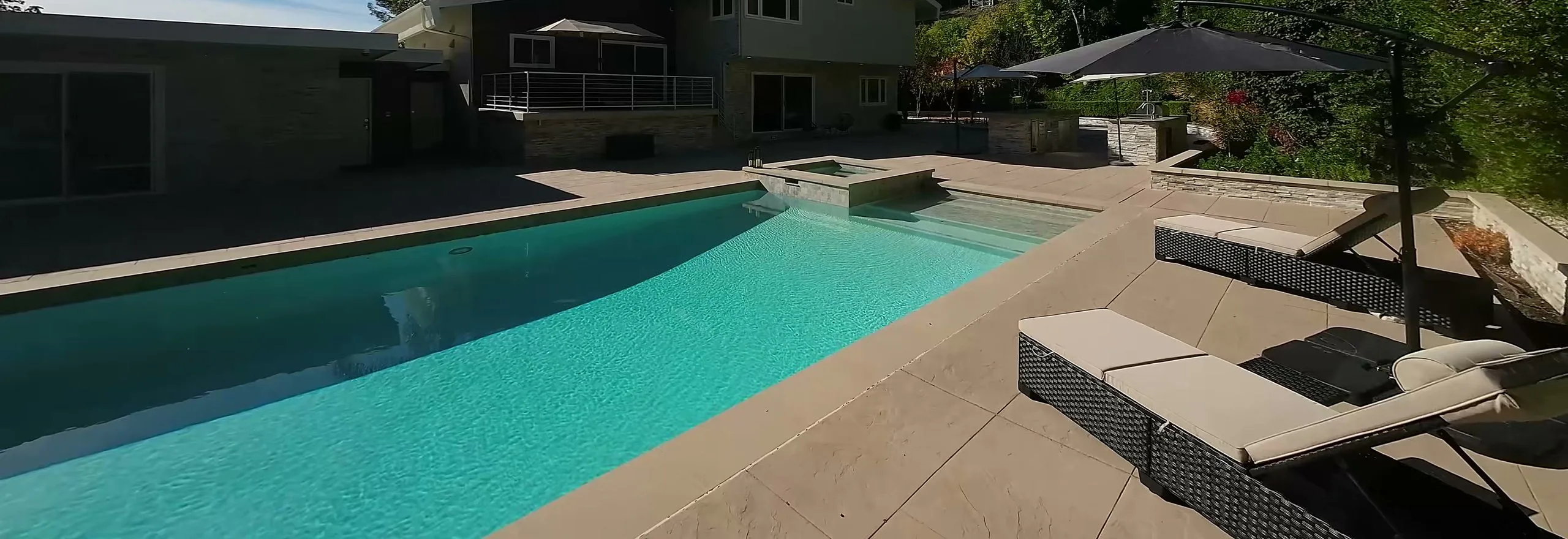 Pool, spa and lounge chairs behind the house